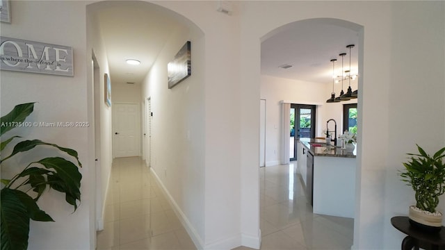 hall with light tile patterned flooring and sink