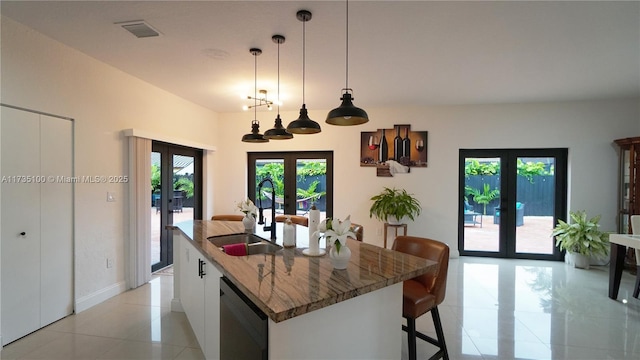 kitchen featuring dishwasher, sink, white cabinets, a kitchen island with sink, and french doors