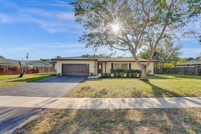 ranch-style home featuring a garage and a front yard