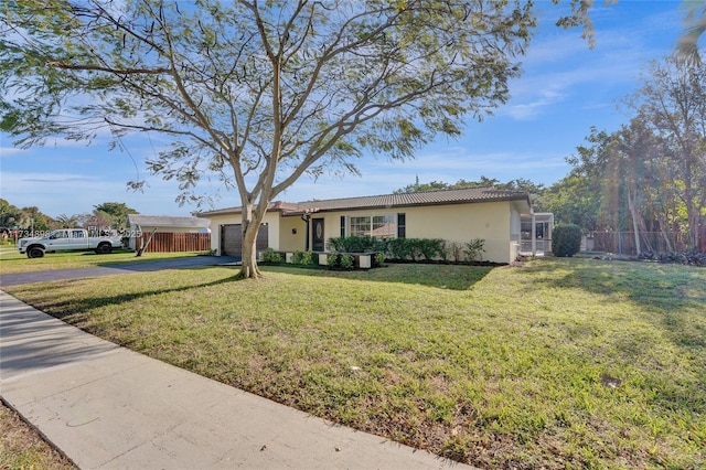 ranch-style home with a garage and a front lawn