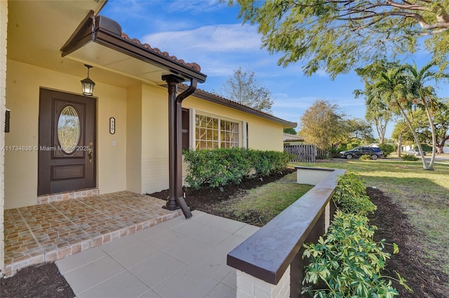 view of exterior entry featuring a yard