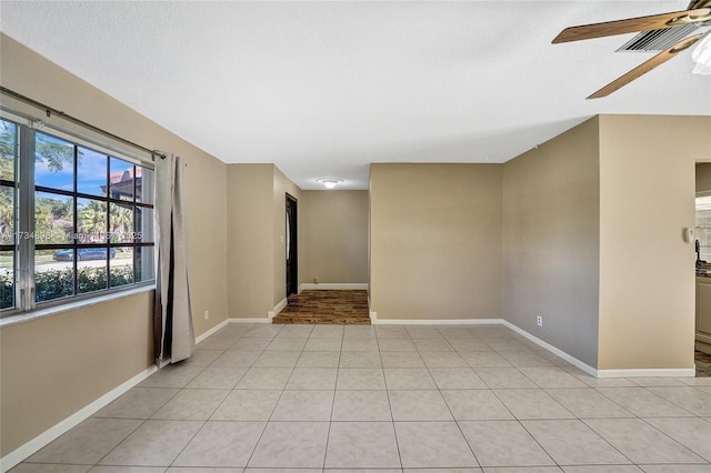 tiled spare room featuring ceiling fan and a textured ceiling