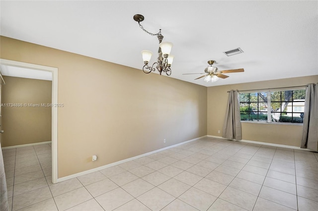 tiled spare room featuring ceiling fan with notable chandelier