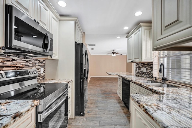 kitchen featuring sink, black appliances, ceiling fan, light stone countertops, and backsplash