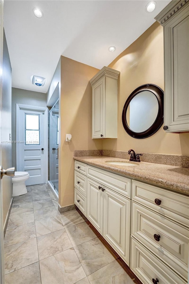 bathroom with vanity, an enclosed shower, and toilet