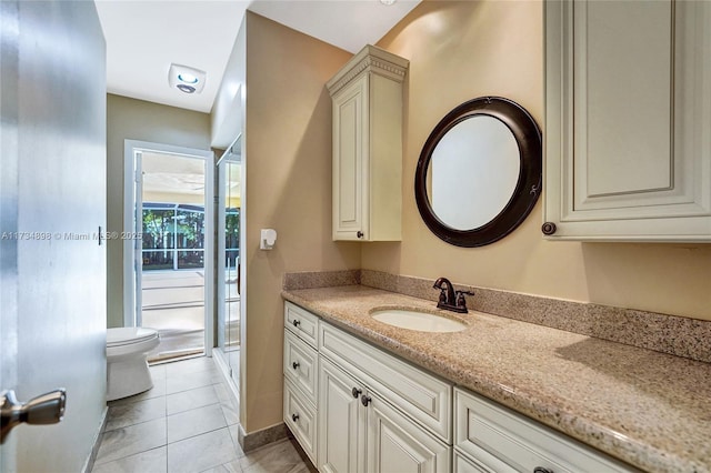 bathroom with vanity, a shower with shower door, tile patterned floors, and toilet