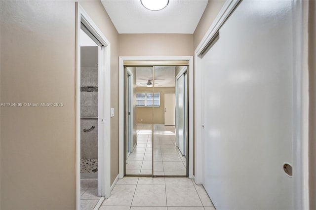 hall featuring light tile patterned floors and a textured ceiling