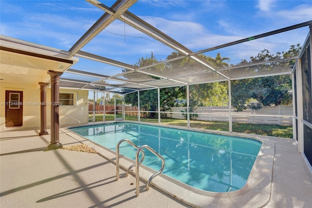 view of swimming pool featuring a patio and glass enclosure