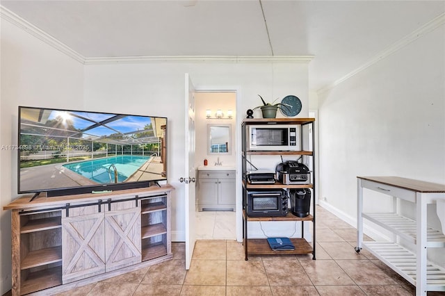 kitchen with light tile patterned floors, ornamental molding, and sink