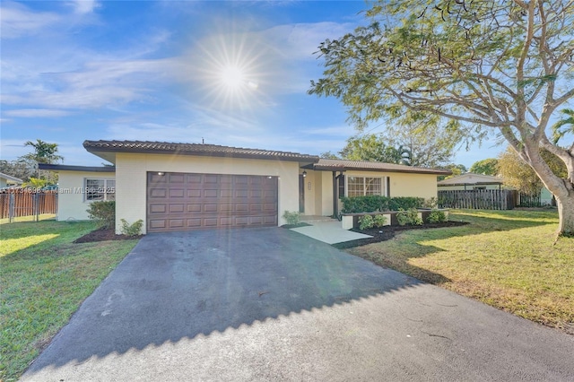 ranch-style house with a garage and a front lawn