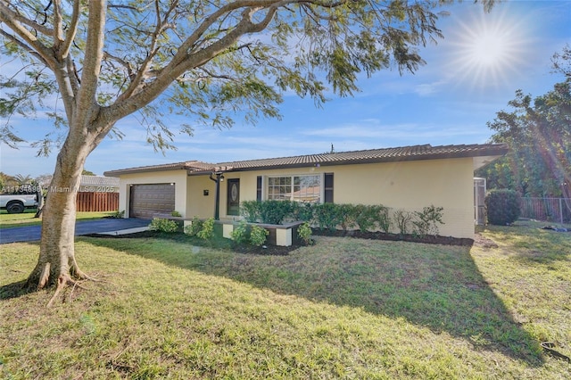 ranch-style house with a garage and a front lawn