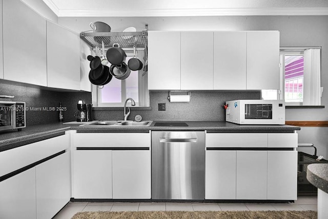 kitchen featuring a kitchen bar, white cabinetry, crown molding, high end refrigerator, and vaulted ceiling