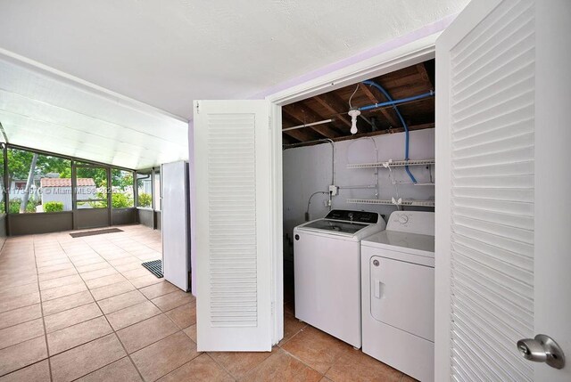 washroom with separate washer and dryer and light tile patterned floors