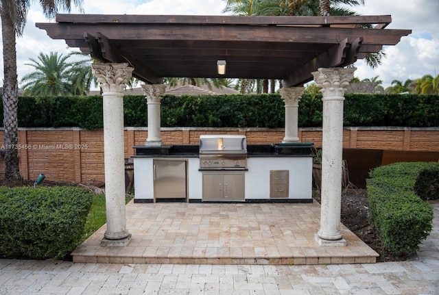 view of patio featuring a grill, a pergola, and exterior kitchen