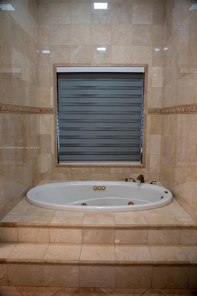 bathroom featuring tile walls and tiled bath