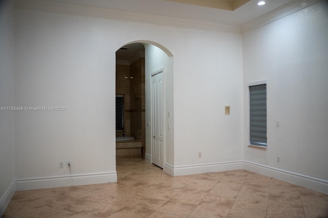 tiled spare room featuring crown molding