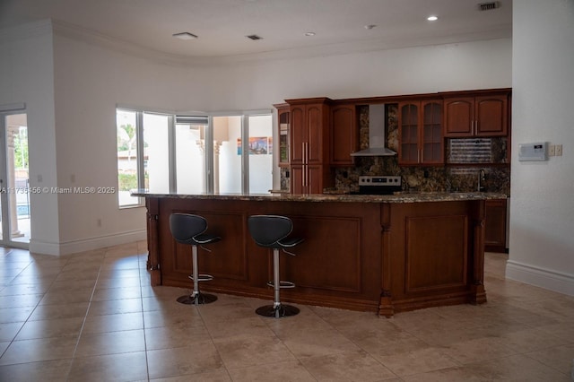 kitchen with stainless steel range with electric stovetop, stone countertops, ornamental molding, decorative backsplash, and wall chimney range hood