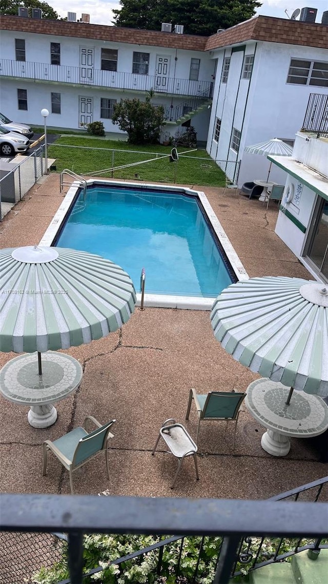 view of swimming pool featuring a yard