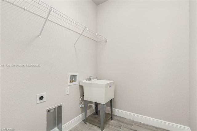 clothes washing area with washer hookup, hookup for an electric dryer, and light hardwood / wood-style floors