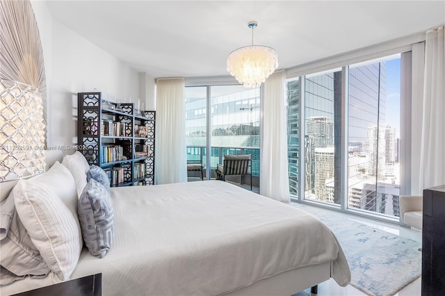 bedroom with a wall of windows, access to exterior, and a chandelier