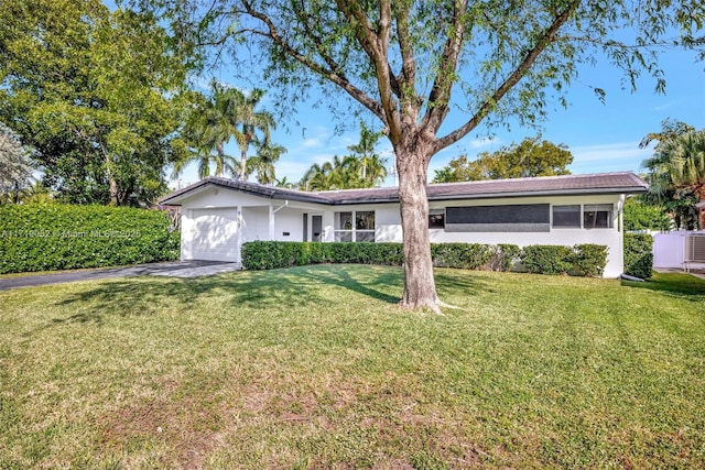 single story home featuring a garage and a front yard