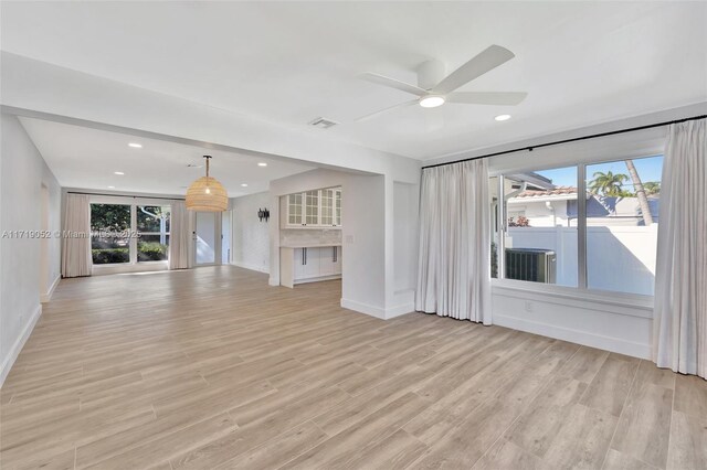 unfurnished living room featuring ceiling fan, plenty of natural light, and light wood-type flooring