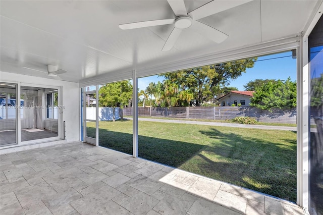 unfurnished sunroom with ceiling fan