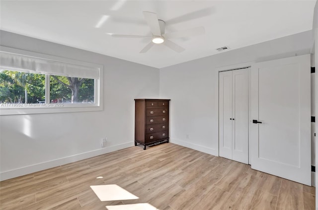 unfurnished bedroom featuring ceiling fan, light hardwood / wood-style floors, and a closet