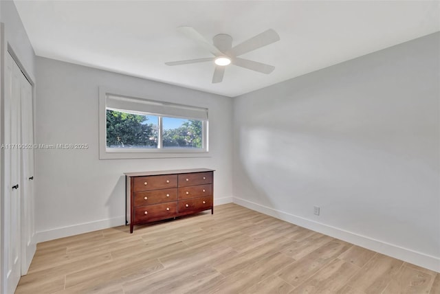 unfurnished bedroom featuring light hardwood / wood-style flooring, a closet, and ceiling fan