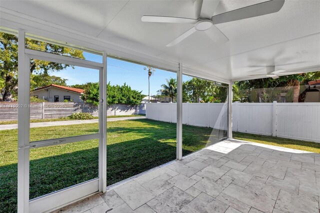 unfurnished sunroom with ceiling fan