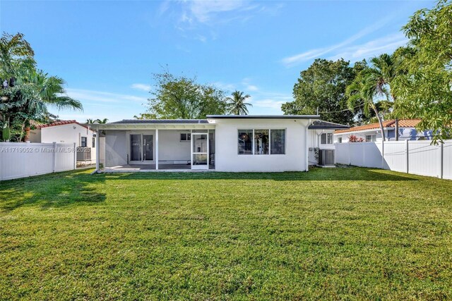 rear view of house with a yard, central AC unit, and a patio area