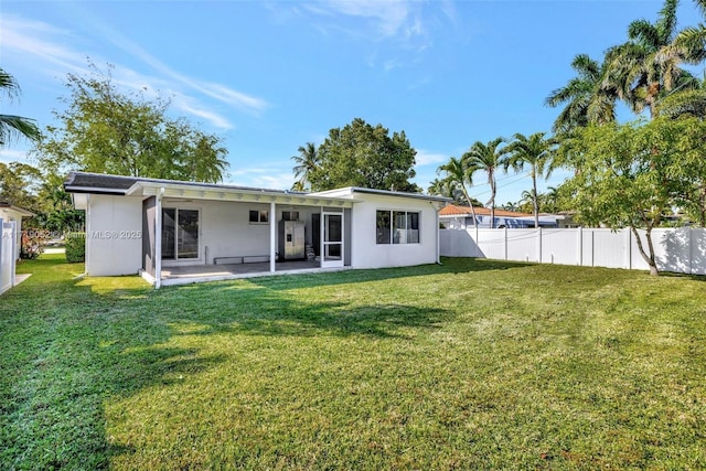 rear view of property featuring a patio area and a lawn