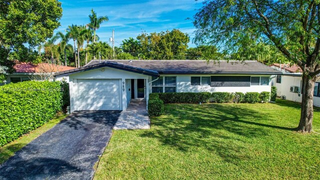 single story home featuring a garage and a front yard