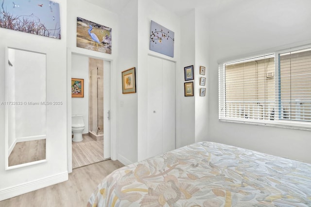 bedroom with connected bathroom, light hardwood / wood-style floors, and a closet