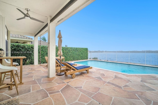 view of pool featuring a patio, ceiling fan, and a water view