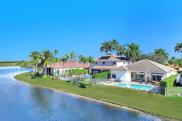 exterior space featuring a water view, a yard, and a fenced in pool