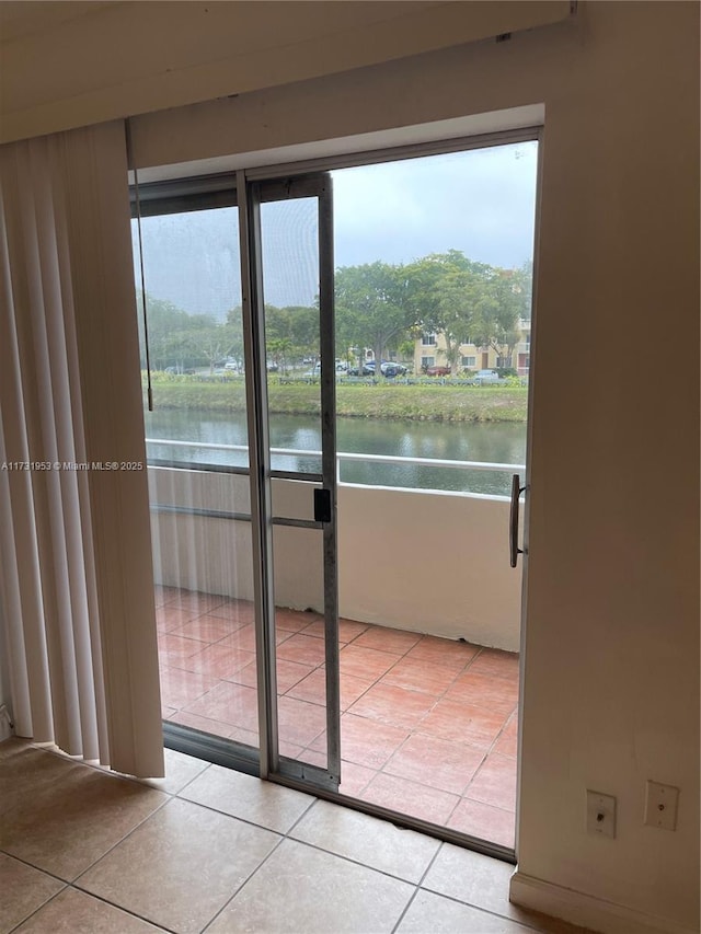 entryway with light tile patterned flooring and a water view