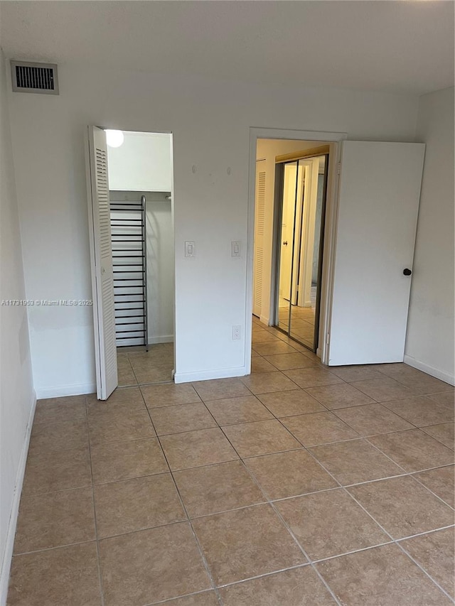 unfurnished bedroom featuring light tile patterned flooring and a closet