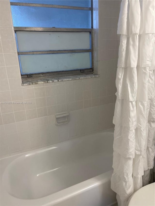 bathroom with shower / bathtub combination with curtain