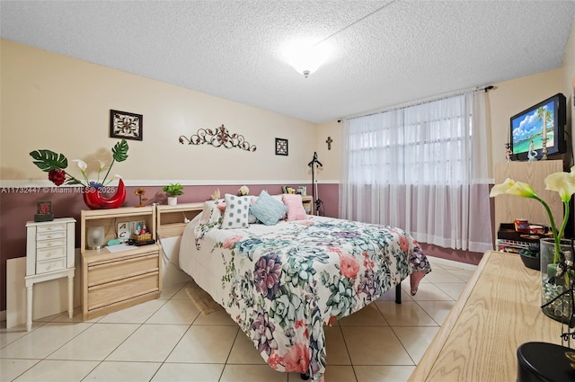 bedroom featuring light tile patterned flooring and a textured ceiling