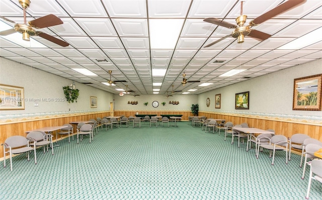 misc room with ceiling fan, carpet flooring, and wood walls