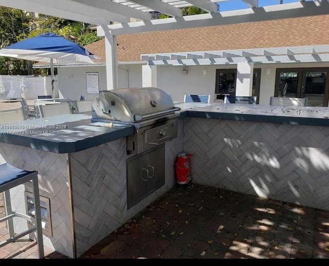 view of patio / terrace with a grill, a pergola, an outdoor bar, and exterior kitchen