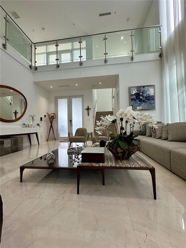 living room with french doors and a high ceiling