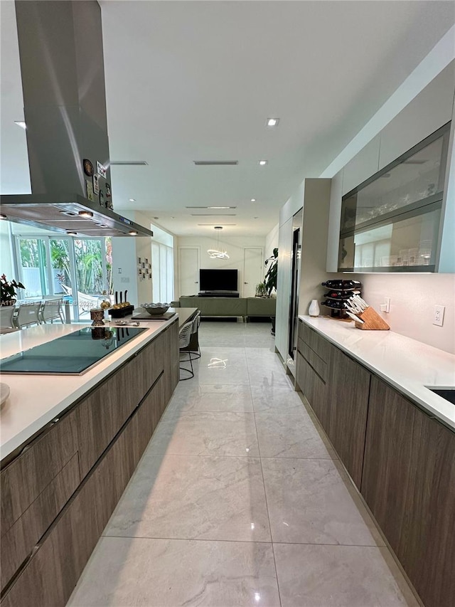 kitchen with island exhaust hood, black electric stovetop, and dark brown cabinets