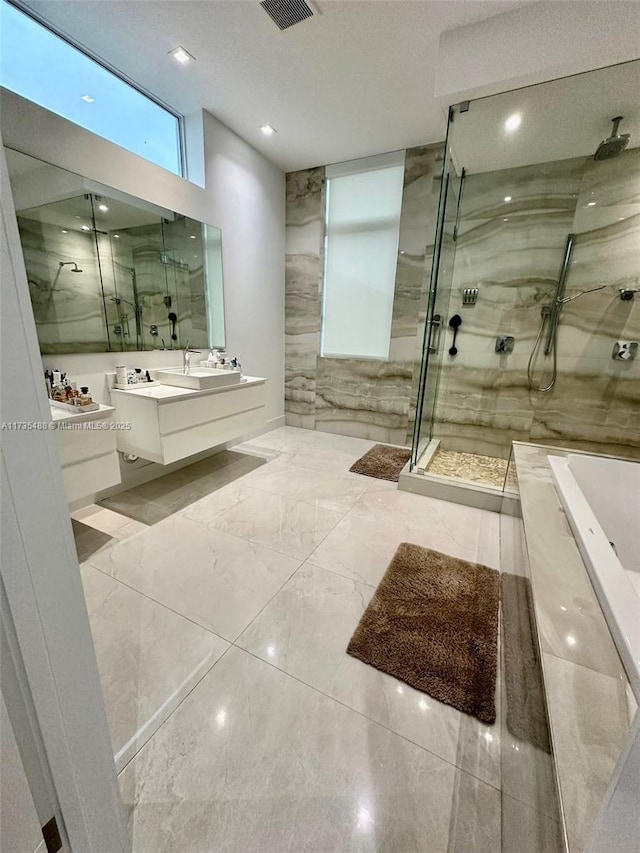 bathroom with vanity and independent shower and bath