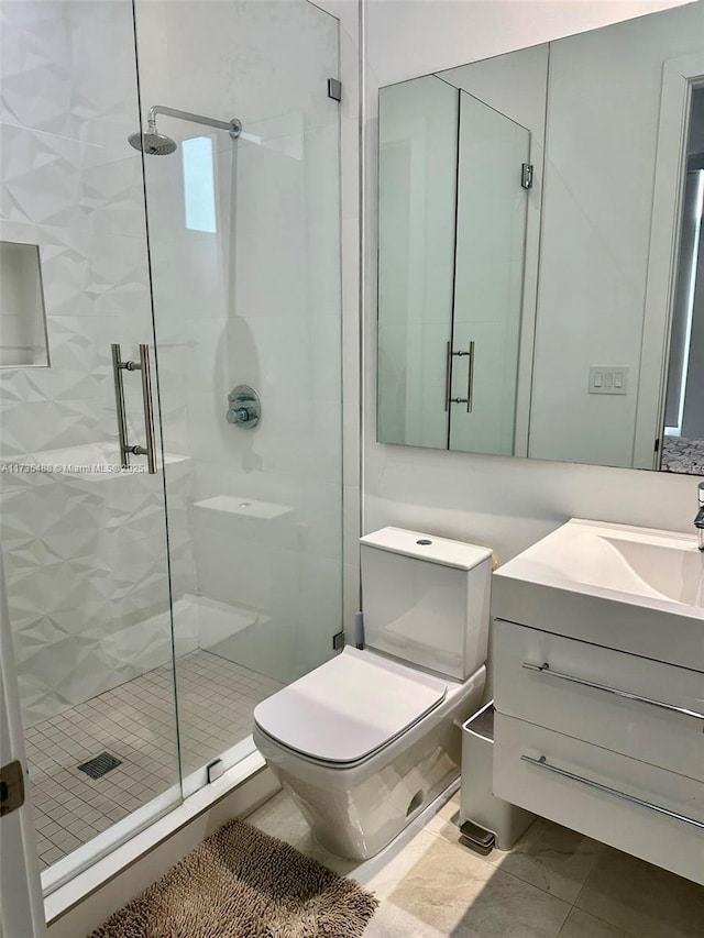 bathroom featuring vanity, toilet, and a shower with door