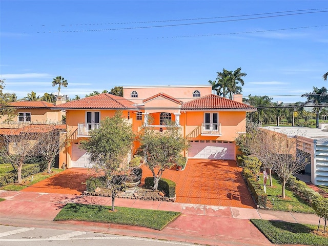 mediterranean / spanish house with a garage and a balcony