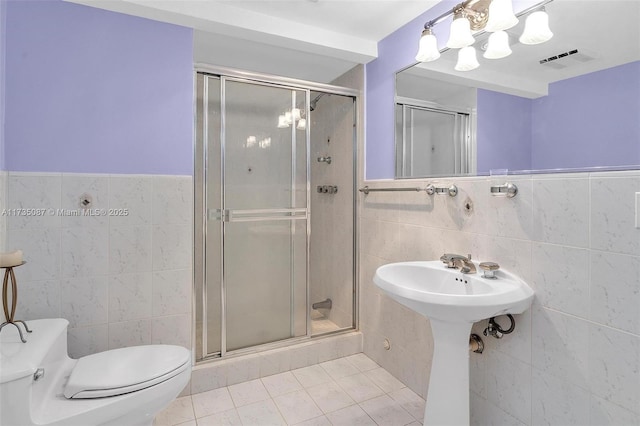 bathroom with tile walls, a shower with door, and toilet