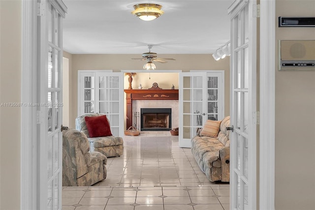 living area featuring french doors, ceiling fan, and light tile patterned flooring