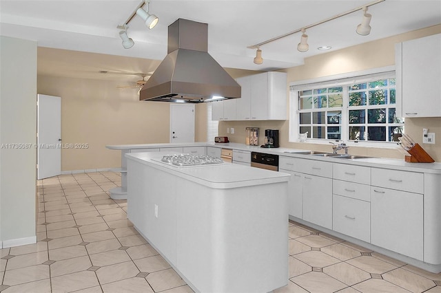 kitchen featuring white cabinetry, sink, stainless steel gas stovetop, and island exhaust hood